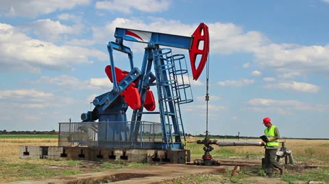 Monitoring oil pump and wipe sweat from face. Stock Footage 39763833