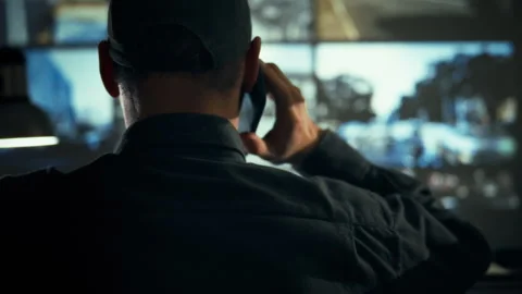 In a monitoring service control room an employee speaks on the phone while s Stock Footage 334545817