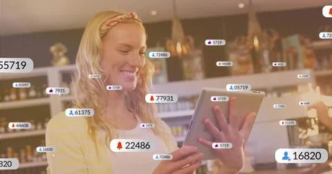 Monitoring staff using tablet smartphone with floating icons at cafe counter Foto stock