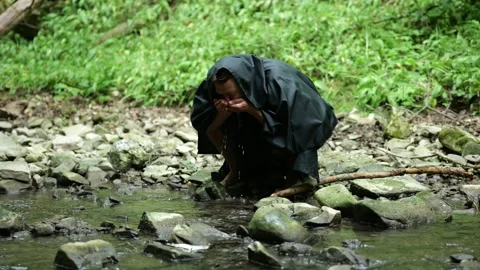 Monk Drinking from a Stream During His Journey Stock Footage 336696203