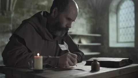 Monk with a feather pen transcribing from an open book Stock Footage 338992028