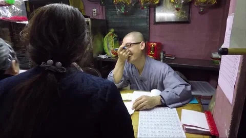 Monk Helps a Visitor to Fill Out a Prayer Card, Chua Phuoc Hai Temple, Vietnam Vídeos de archivo 271667767