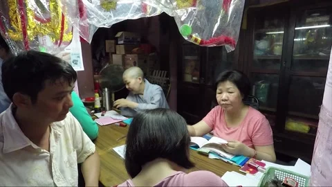 Monk Helps a Visitor to Fill Out a Prayer Card, Chua Phuoc Hai Temple, Vietnam Stock Footage 271680340
