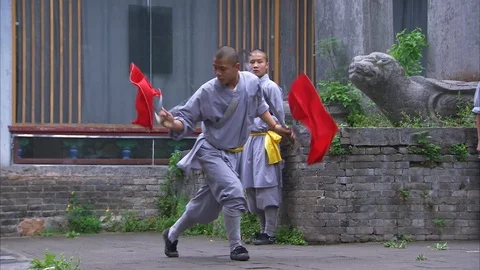 Monk performing with sword while other students stand back Stock Footage 89813163