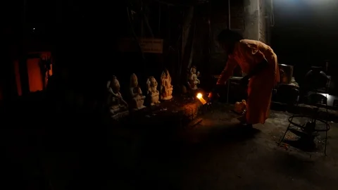 Monk performs night aarti near hindu idols with fire in yard of temple Stock Footage 100299810
