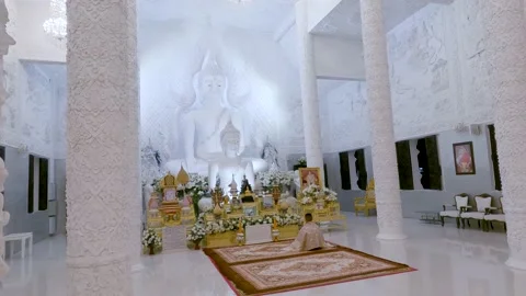 Monk praying in front an altar inside white temple 動画素材 168838879