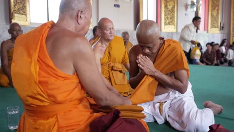 Monk praying  sitting in front of abbot. Ordaining ceremony to be a monk Stock Footage 161787199