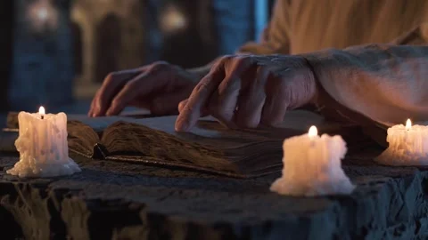 Monk reading an ancient book by candlelight. Stock Footage 313115401