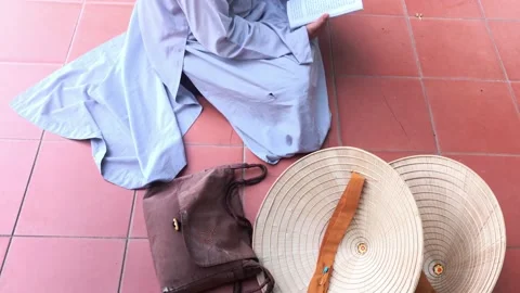 A monk sits on the ground and reads scripture book Video stock 142675111