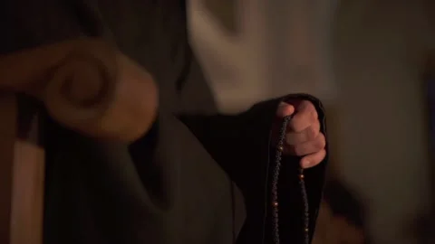 The monk is sorting out the rosary. Prayer in the temple Stock Footage 236758401