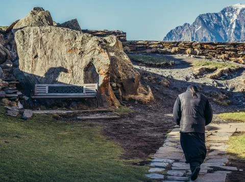 Monk walks next to Tsminda Sameba church in Georgia Stock Photos