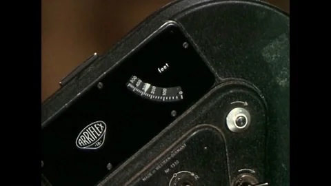 A monkey uses a motion picture camera with lenses on a tripod in a studio. Stock Footage 88873259