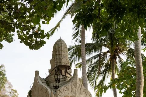 Monkey walking on temple structure near tropical beach 스톡 사진