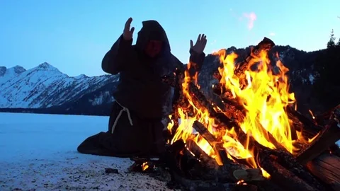 Monks are warming near fire in winter Stock Footage