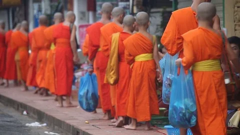 Monks collecting alms village Laos Stock Footage