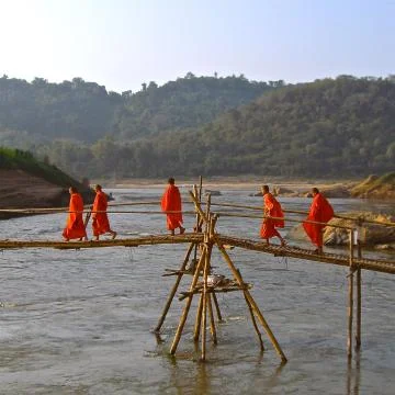 Monks on a rustic bridge Stock Photos