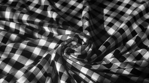 A monochromatic checkered fabric spirals into a hypnotic pattern, evoking a Stock Footage 255843776