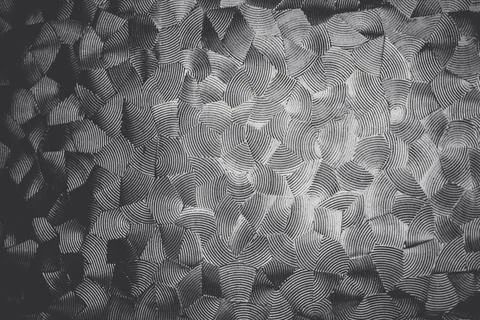 Monochromatic, textured pattern on glass with overlapping, undulating lines.. Stock Photos