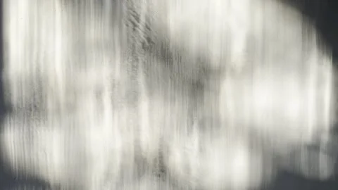 Monochrome abstract light play dances across textured grey wall with soft blurre 스톡 동영상 333569052