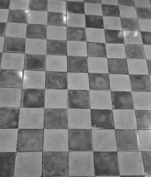 Monochrome checkerboard tile pattern creates a striking contrast on a flat fl Stock Photos