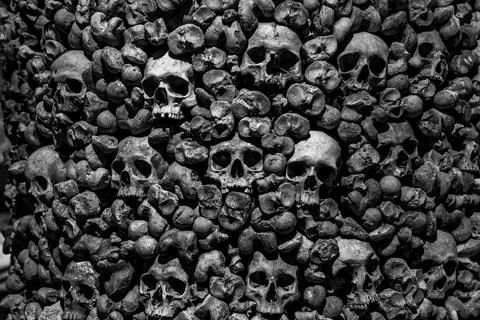 Monochrome image of densely packed human skulls and bones 스톡 사진