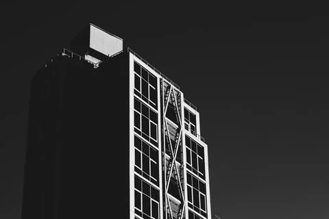 A monochrome image of a modern building with an external support structure .. Stock Photos