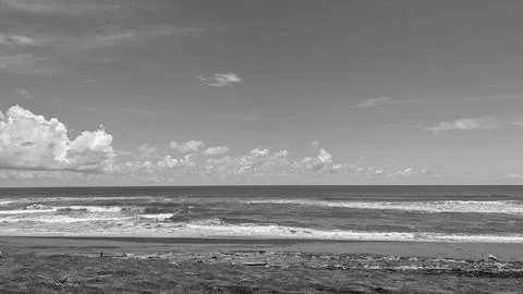 Monochrome panoramic landscape view captures rolling ocean waves crashing o.. Stock Photos