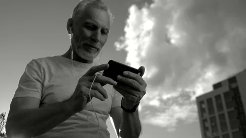 Monochrome of a positive senior man talking via the Internet Stock Footage