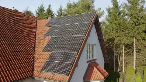 Monocrystalline photovoltaic panels made of solid silicon crystal on tiled roof. Stock Footage 255320654
