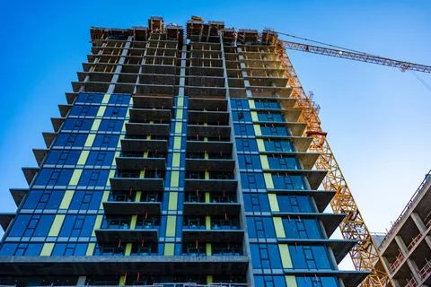 Monolite concrete building under constraction on blue sky background. Mono... Stock Photos