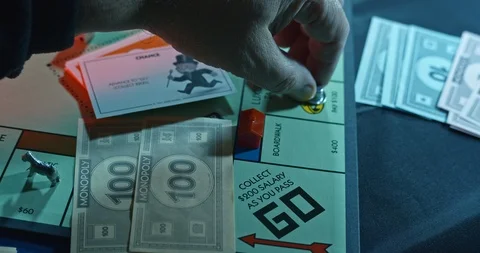 Monopoly board game. Player moves Hat to GO collects $200. Close Up Stock Footage 122407224
