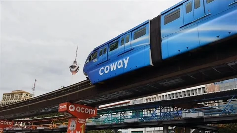 Monorail train moving on the track with Kuala Lumpur Tower in the background Stock Footage 324547045