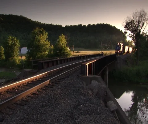 Monroe, OH; Coal train slowly approaches and passes camera in late afternoon sun Stock Footage 86695196