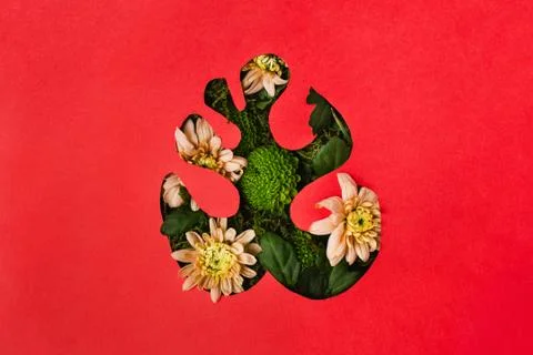 Monstera leaf shape cutout from red paper with green and flowers, flatlay Stock Photos