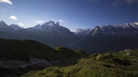 Mont blanc mountain range snowy peak sun shine over green alpine ridge blue sky Stock Footage 340861555