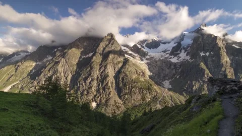 Mont blanc mountain range snowy peak cloud drift over rocky cliff alpine valley Stock Footage 340862304