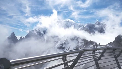 Mont blanc observation deck metal rail snowy peak cloud drift across blue sky Stock Footage 340869269