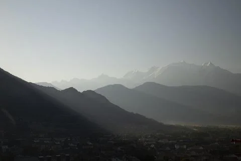 Mont blanc range sunrise creating crepuscular rays over valley Stock Photos