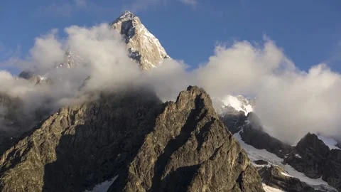 Mont blanc sharp snowy peak cloud swirl around rocky cliff clear blue sky Stock Footage 340861964