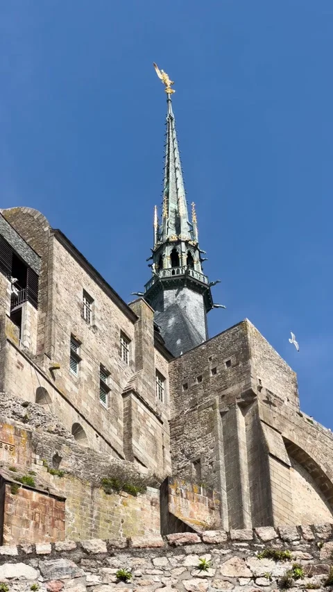 Mont Saint-Michel Abbey Spire and Stone Walls Viewed from Below on Clear Day Stock Footage 342052265