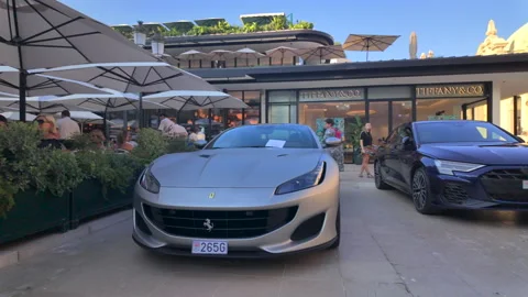 Monte Carlo, Monaco - August 21, 2024: Luxury cars parked in front of a Tiffany Stock Footage 306350215