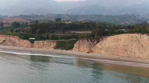 Montecito beach aerial pulling away over glassy ocean on hazy day Stock Footage 173519811