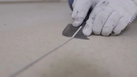 Month-old knife cuts off the excess welding cord after a hot spike of linoleum Stock Footage 147174332