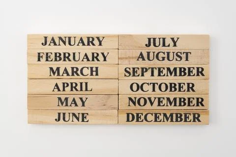 The months of the year written on twelve rectangular pieces of wood 스톡 사진