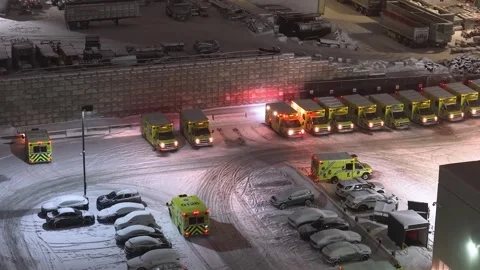 Montréal, Canada Dec '25 - Snow-dusted ambulance depot waiting through the night Stock Footage 324868754