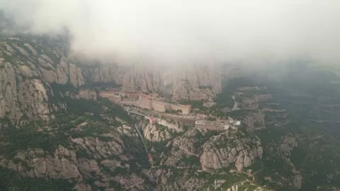 Montserrat Monastery. Drone view. Drone flies under clouds towards the monastery Video stock 299954576