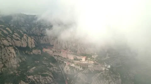 Montserrat Monastery. Drone view. Drone flies under clouds towards the monastery 스톡 동영상 303107877