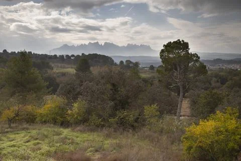 Montserrat mountain range appearing from distant landscape Stock Photos