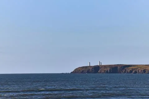 Monument on cliff, distant view with ocean and clear sky with copy space. Met Stock Photos