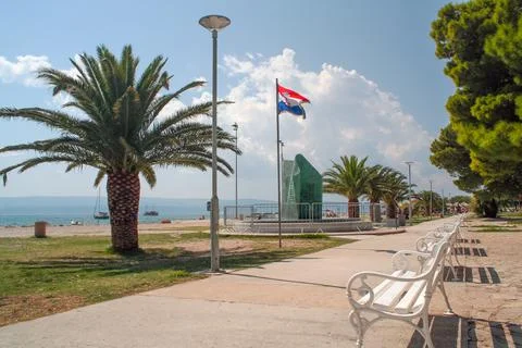 Monument to the Fallen and palm tree on the beach by the sea, Omis, Croatia Stock Photos